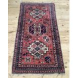 A middle eastern rug, the rose pink ground having three medallions filled with diamond shaped flower