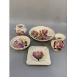 Five items of Moorcroft magnolia pottery tube lined and glazed in pink on a cream ground