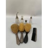 Three silver backed hair brushes together with a silver topped comb and four glass scent bottles
