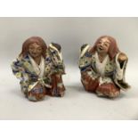 A pair of Japanese pottery seated figures in flower decorated robes (faults) approximately 13cm