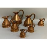 A set of seven copper jugs of graduated size from half-gallon, quart, pint, half-pint, one gill,