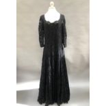 A full-length black lace dress embellished throughout with tiny black beads, by “Olvis”