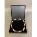 A Belgian designed necklace, boxed, eight large ginger beads separated by three different colours of