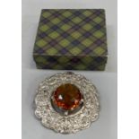 A large plaid brooch in white base metal all over chased with a thistle pattern, claw set to the