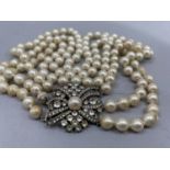 A necklace of three strands of 7mm simulated pearls fastened with a silver cluster snap, approximate