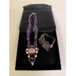 Modern Belgian design: A necklace and bracelet set in hues of purple and pink, the upper beaded