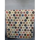 A Grandmother’s Flower Garden pieced quilt top, currently backed in cream cotton, 20th century but