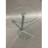A glass topped occasional table of circular outline on a chrome support and glass circular base,