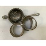 silver napkin rings all engraved (at fault) together with an EPNS tea strainer, total approximate