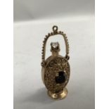 A garnet and spinel set scent bottle charm/pendant in 9ct gold, claw set to each side with an oval