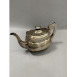 A George III silver teapot of oval outline, with engraved border to the rim, lid and handle feet