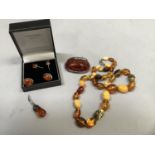 A small collection of Baltic amber set jewellery in silver including an oval brooch, two pairs of