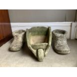 Two cast boot garden planters together with a cast barrow planter