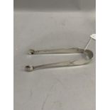 A pair of early 19th century silver bright cut sugar tongs with engraved monogram to an oval