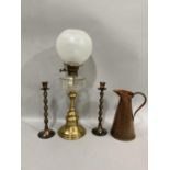 A hammered copper ewer, brass oil lamp with orb shade together with pair of copper bobbin candle