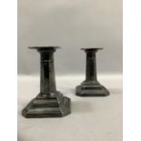 A pair of George V silver candlesticks with octagonal stems over a weighted octagonal foot,
