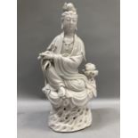 A Chinese blanc de chine figure of a female deity holding a scroll in her hand, 32cm high