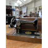 A Singer sewing machine with enamel decoration and associated cover