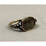 A George II mourning ring in 15ct gold and silver, with dressed hair on oval glazed backed collet