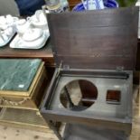 An oak wash stand having a lift up top, the interior fitted with an aperture for a bowl and soap