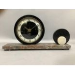 An Art Deco mantel clock, the circular dial with black Arabic numerals on a rouge marble plinth base