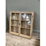 Pine and glazed two door hanging wall cupboard with brass latch, three internal shelves, 110am