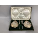 A boxed pair of George V silver butter dishes by Goldsmiths & Silversmiths, each of scallop form
