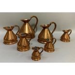 A set of seven copper jugs of graduated size from half-gallon, quart, pint, half-pint, one gill,