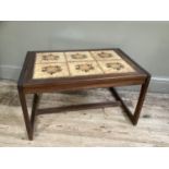 A 1970's teak coffee table with two stretchers, the top inset with tiles, 75cm wide, 50cm deep