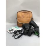 Canon AV-1 camera in leather case together with two lenses and accessories in leather case