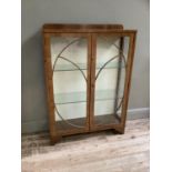 An Art Deco walnut veneered and glazed two door door display cabinet, on bracket feet, 93cm wide x