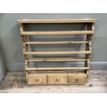 A set of pine Delft hanging wall shelves with three plate racks above three short drawers with
