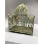 A green wire ornate bird cage with four acorn finials, arched door and ring pull handle ,