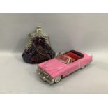 A reproduction friction model pink convertible of American style 27cm long, together with a beaded