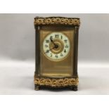 A gilt carriage clock, French movement, having a porcelain dial with Arabic numerals, exposed
