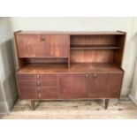 A 1960/70s teak side cabinet with fall down front above four short drawers, two door cupboard