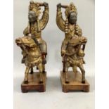 A pair of Chinese carved giltwood male and female mounted on horses, in ceremonial dress, detailed