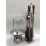 A brushed chrome and teak fireside companion with tongs, brush, shovel and poker together with