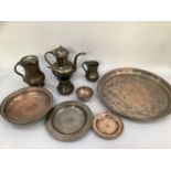 A collection of Middle Eastern copper vessels including coffee pot, three mugs or jugs, plate,