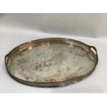 A silver plated on copper two handled tray of oval outline with pierced gallery, 61cm by 44cm