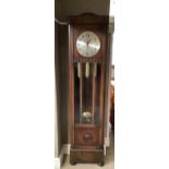 A 1930s oak long cased clock having a circular silvered dial with black Arabic numerals with