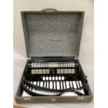 A Hohner piano accordion, Verde III in black casing with black lacing buckle strap in grey leather