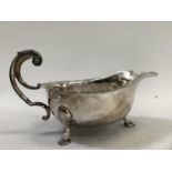 A George V silver sauce boat with double scroll handle, on three hoof feet, by Viners, Sheffield