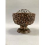 A Japanese plated on copper rose bowl, cast in relief with heavily laden blossom trees on a pedestal