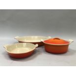 A Le Creuset orange oven dish, oval, together with another smaller circular and a small lidded