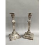 A pair of late Victorian/Edwardian plated on copper candlesticks, the sconce and column embossed