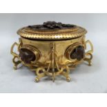 A French gilt metal casket of oval outline, the beaded cover inset with wood panel carved in