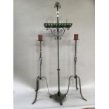 A pair of metal twisted candle stands and a wrought iron freestanding candelabra on three scrolled