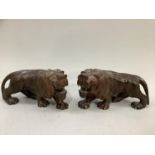 A pair of Japanese carved hardwood figures of prowling lions, inset bone eyes, teeth and claws Meiji