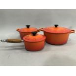 Le Creuset orange twin handled cook pot together with another twin handled cook pot, smaller, and